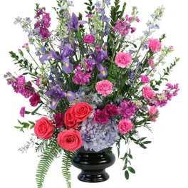 Tall mixed bouquet in a black vase with pink, purple, and blue flowers