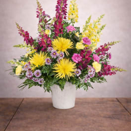 Colorful mixed flower arrangement in a white pot