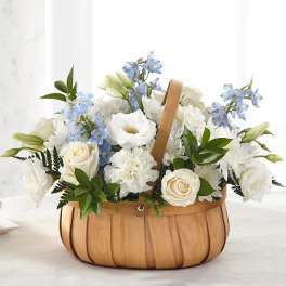 Basket of white flowers with pale blue blooms and greenery