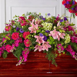 Large pink and purple floral casket spray with lilies and roses