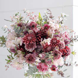 Large pink and burgundy bouquet in a clear glass vase
