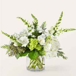 White and green floral arrangement in a clear glass vase