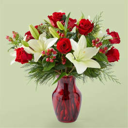 Red roses and white lilies in a red glass vase