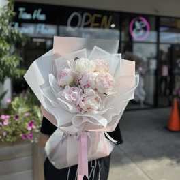 Pink and white peony bouquet wrapped in translucent paper