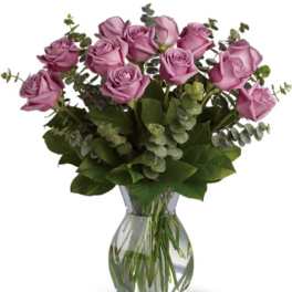Lavender roses arranged in a clear glass vase