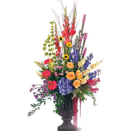Tall mixed flower arrangement in a dark urn vase