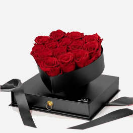 Heart-shaped bouquet of red roses in a black box with ribbon