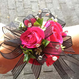 Small bouquet of bright pink roses with black ribbon loops