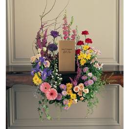 Colorful floral wreath around a cardboard box on a stand