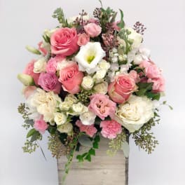 Pink and white floral arrangement in a wooden box