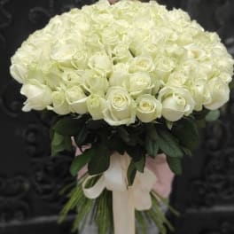 Round bouquet of white roses with a pale ribbon wrap
