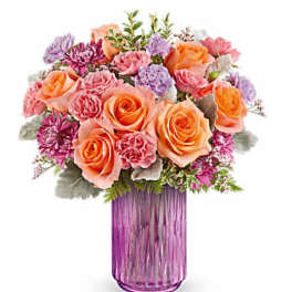 Bouquet of peach and pink roses in a purple glass vase