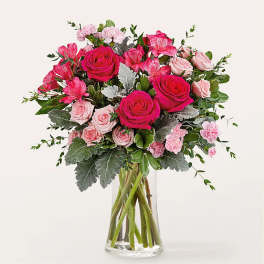 Pink roses and carnations in a clear glass vase