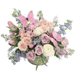 Pastel bouquet in a basket with pink butterflies
