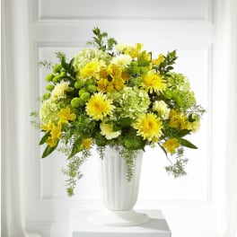 Yellow and white floral arrangement in a white vase