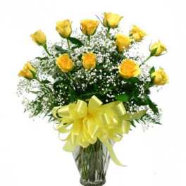 Yellow roses in a glass vase with baby's breath and a yellow bow