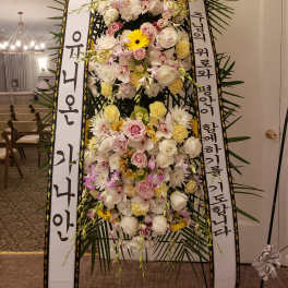 Tall standing floral wreath with white and pink flowers and Korean condolence ribbons