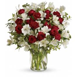 Bouquet of red roses and white alstroemeria in a clear glass vase