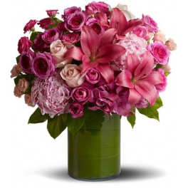 Pink and purple flower bouquet in a green glass vase