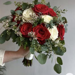 Bouquet of red and white roses with greenery and small white filler flowers