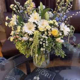 Mixed bouquet of white and yellow flowers in a glass vase