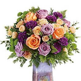 Bouquet of peach, lavender, and purple roses in a iridescent vase