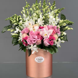 Pink and white floral arrangement in a rose-gold cylindrical box