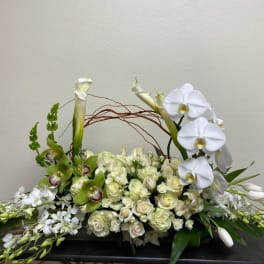 White floral arrangement with orchids, roses, and calla lilies