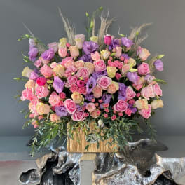 Large bouquet of pink and purple roses in a gold container