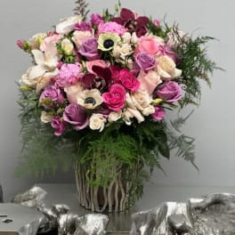 Bouquet of pink, purple, and white flowers in a woven vase