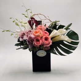 Bouquet of pink roses, orchids, and white calla lilies in a black box