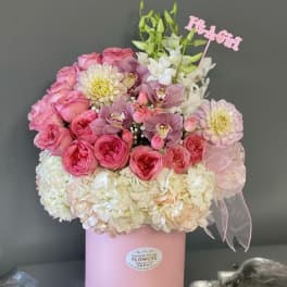 Pink and white bouquet in a pink hat box with a ribbon
