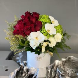 Bouquet of red roses and white orchids in a white hat box