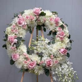 Pink and white floral wreath on a wooden easel