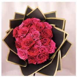 Bouquet of pink and red roses wrapped in black paper with gold trim