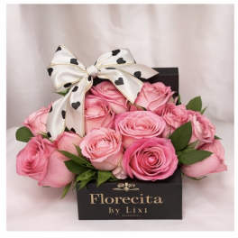 Pink roses in a black gift box with a heart-patterned bow