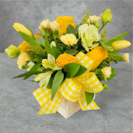 Yellow and white flower arrangement with a gingham ribbon in a square box
