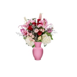 Pink and red flowers arranged in a pink vase