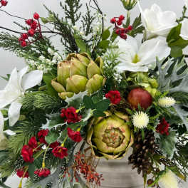White flowers and artichokes in a festive holiday arrangement