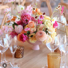 Pastel floral centerpiece in a pink vase on a table