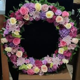 Heart-shaped floral wreath with pink, purple, and white blooms