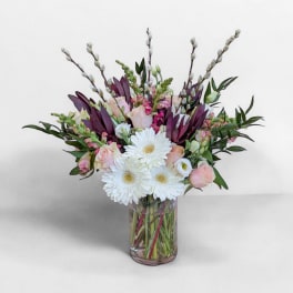 Pink roses and white daisies in a clear glass vase