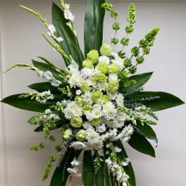 Tall white and green floral standing arrangement on an easel