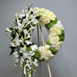 Large white floral wreath on a wooden easel