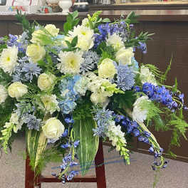 Large blue, white, and cream floral arrangement with cascading blooms