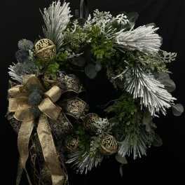 Holiday wreath with silver accents, gold ribbon, and dark greenery