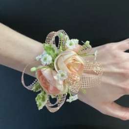 Peach and white floral wrist corsage with ribbon loops