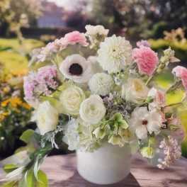 Pastel bouquet of white and pink flowers in a white vase