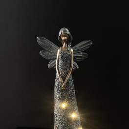 Decorative angel figurine with glowing lights on a dark background