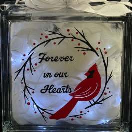 Illuminated glass block with red cardinal, memorial text, and white ribbon bow on top